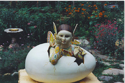 A restored Sergio Bustamante butterfly girl emerging from a monumentally sized egg.